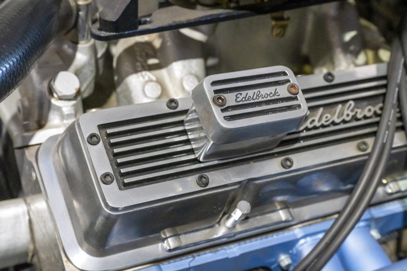 Close-up of a polished engine rocker cover on a vehicle in the workshop