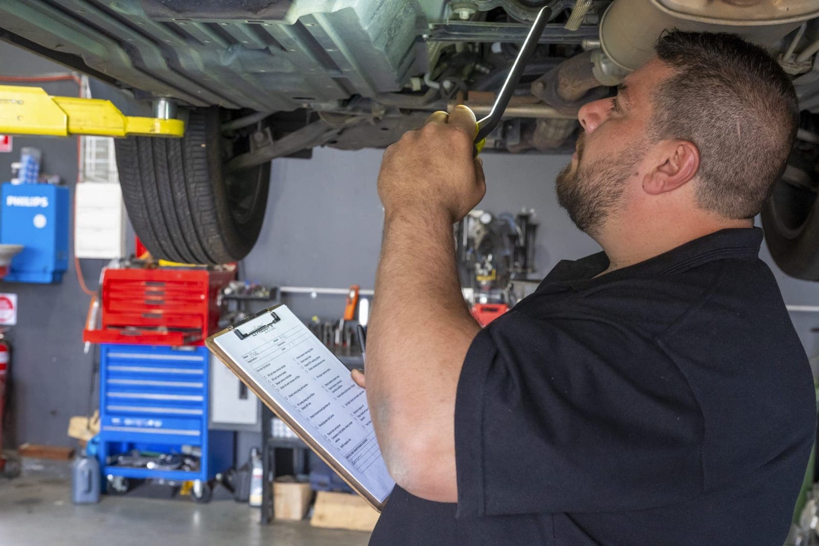 Mechanic working underneath a raised vehicle